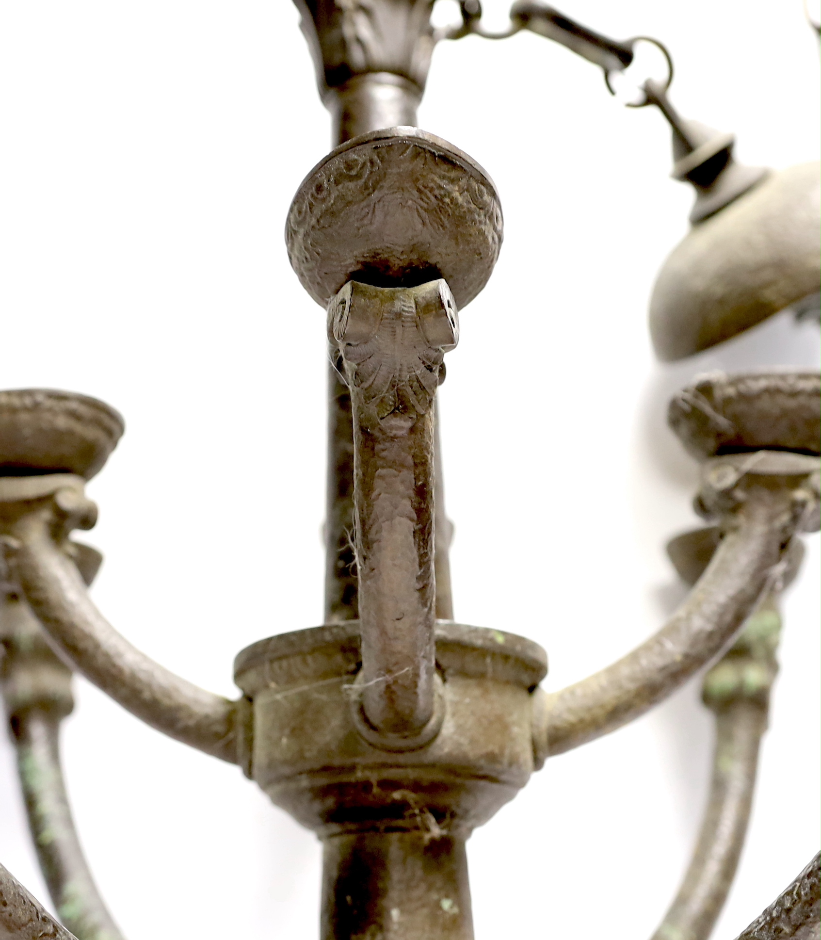 A bronze hanging ceiling light, with two tiers and eight face mask branches and large central chain, approx 47cm high not including chain